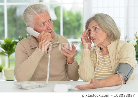 Portrait of senior couple measuring blood pressure together Portrait of senior couple measuring blood pressure together 108058887