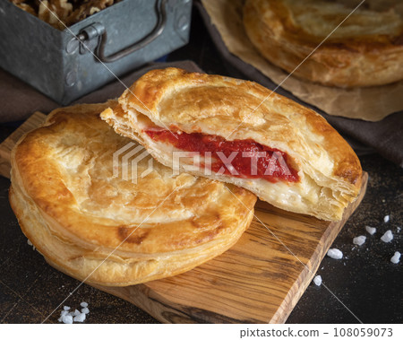 Rustico puff pastry from Lecce filled with stuffed with tomato, mozzarella and bechamel sauce 108059073