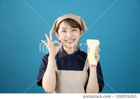 House cleaning female worker holding towel against blue background 108059263