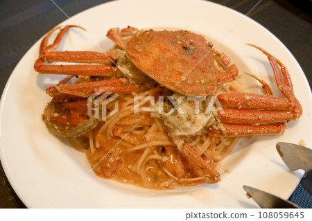 Tomato sauce pasta topped with a whole red crab Tomato sauce pasta topped with a whole red crab 108059645