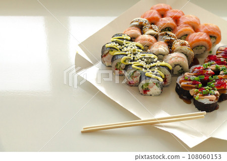 Sushi rolls in disposable paper box on table Sushi rolls in disposable paper box on table 108060153