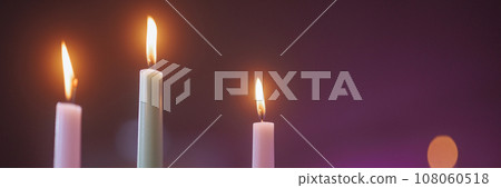 Three white candles with a purple background. Three white candles with a purple background. 108060518
