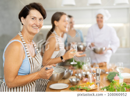 Elderly woman learns to cook at master class 108060952