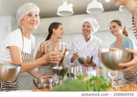 Elderly woman talks and drinks with group during master class Elderly woman talks and drinks with group during master class 108060956