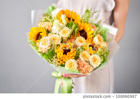 Small Beautiful bouquet of mixed flowers in woman hand. Floral shop concept . Beautiful fresh cut bouquet. Flowers delivery Small Beautiful bouquet of mixed flowers in woman hand. Floral shop concept . Beautiful fresh cut bouquet. Flowers delivery 108060987