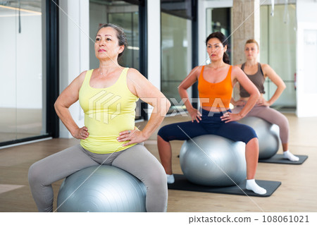 Four women sitting on swiss balls 108061021