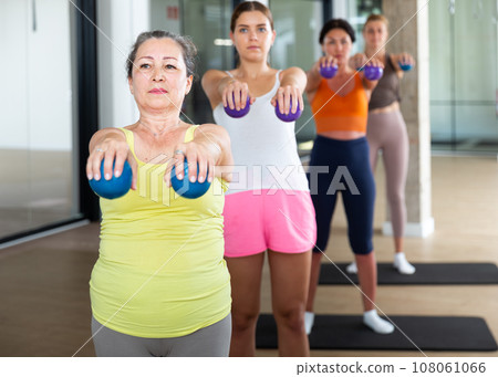 Aerobics pilates women with toning balls in row on fitness class 108061066