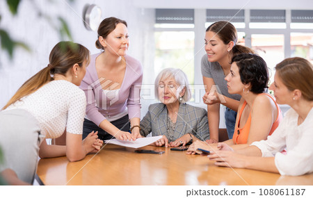 Smiling woman conducting informal work meeting with female colleagues 108061187