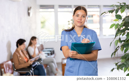 Doctor of clinic in bathrobe is standing in waiting hall and waiting for arrival of patients. Doctor of clinic in bathrobe is standing in waiting hall and waiting for arrival of patients. 108061332