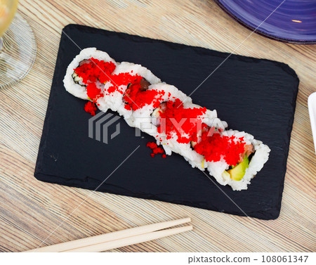 Sushi roll uramaki - tobiko roll with salmon, avocado, pepino, tobiko Sushi roll uramaki - tobiko roll with salmon, avocado, pepino, tobiko 108061347