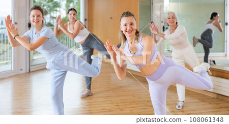 Group of happy women of different ages learning dance movements together in dance class Group of happy women of different ages learning dance movements together in dance class 108061348
