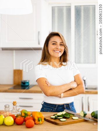 Portrait of pleased housewife preparing salad in kitchen Portrait of pleased housewife preparing salad in kitchen 108061350