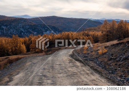 Mountain autumn off-road track to high mountain village in Altai region. Dangerous narrow cliffside mountain road through sharp rocks. Dangerous dirt driving along mountain to edge and steep cliffs. 108062186