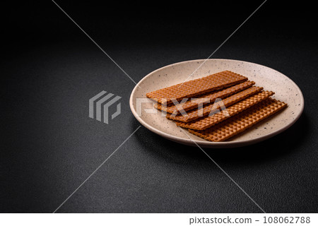 Delicious sweet crispy rectangular waffles on a ceramic plate Delicious sweet crispy rectangular waffles on a ceramic plate 108062788