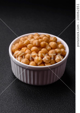 Delicious canned chickpeas in a ceramic plate on a dark concrete background 108062851