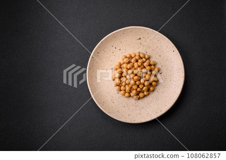 Delicious canned chickpeas in a ceramic plate on a dark concrete background Delicious canned chickpeas in a ceramic plate on a dark concrete background 108062857