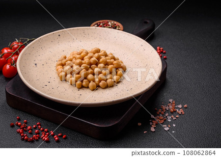 Delicious canned chickpeas in a ceramic plate on a dark concrete background 108062864