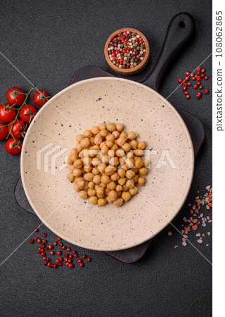 Delicious canned chickpeas in a ceramic plate on a dark concrete background 108062865