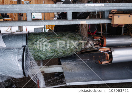 Process of wrapping a Christmas tree in a net. Packing machine. Outdoor market Process of wrapping a Christmas tree in a net. Packing machine. Outdoor market 108063731