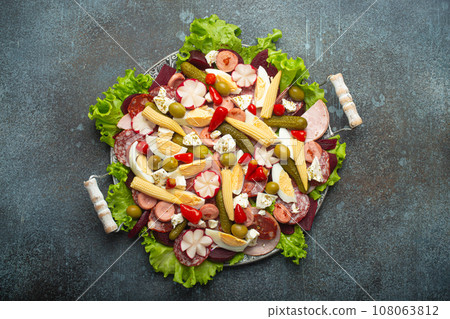 Fiambre, salad of Guatemala, Mexico and Latin America, served on large plate top view. Festive dish for All Saints Day (Day Of The Dead) celebration made of cold cuts, sausages, pickled vegetables 108063812