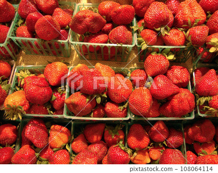 Rows of Strawberries in plastic baskets on display Rows of Strawberries in plastic baskets on display 108064114