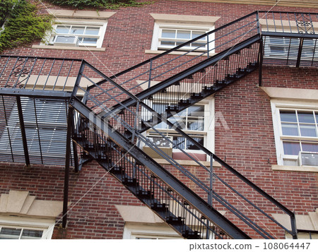 Fire exit on the side of old red brick apartment Fire exit on the side of old red brick apartment 108064447