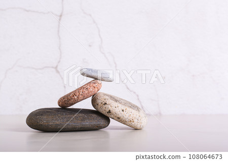 Balancing structure made of smooth sea stones on a table 108064673