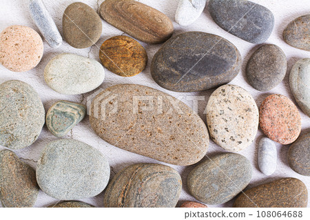 Flat lay background of smooth sea stones on a light background top view Flat lay background of smooth sea stones on a light background top view 108064688