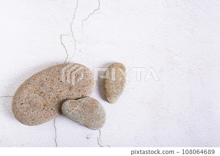 Several smooth sea stones on a light background top view Several smooth sea stones on a light background top view 108064689