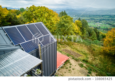 New modern house cottage with solar photovoltaic panel system on roof. Aerial view. Concept of alternative, renewable energy and home autonomy. 108065425