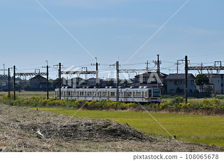 The blue sky seen from the Watarase River embankment and a train running through a rural town, slightly closer: Horizontal composition: Near Shinkoga Station on the Tobu Nikko Line 108065678