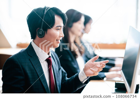 一名年輕人在呼叫中心為客戶服務 108066734
