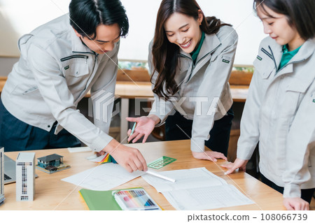 A group of engineers review construction plans using models 108066739