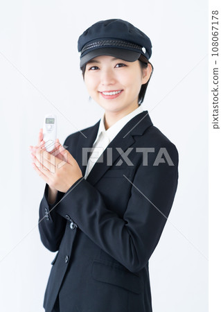 年輕女司機開車前檢查酒精,白色背景 年輕女司機開車前檢查酒精,白色背景 108067178