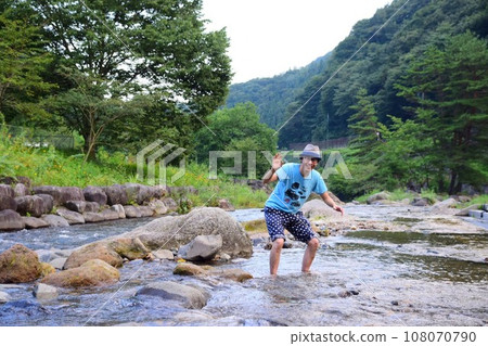 man playing in the river 108070790