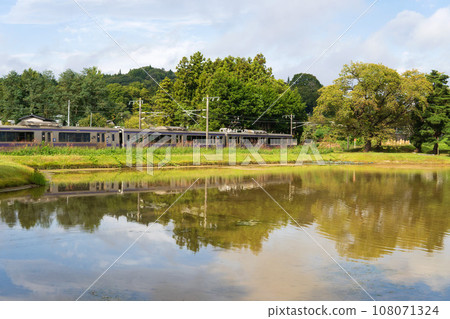 Iwate Prefecture/Train running beside the pond at the World Heritage site Muryoko-in Ruins [Tohoku Main Line] 108071324