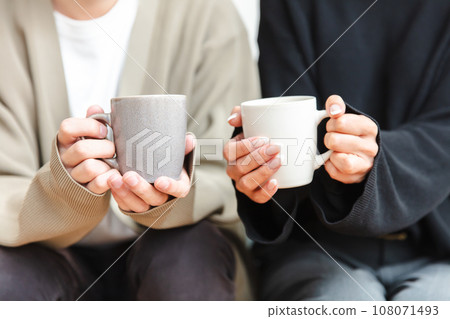 Hands of a man and a woman holding a mug lover 108071493