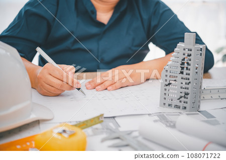 Engineer with collapsed building model, engineer analyzing Cause of building collapse or house collapse 108071722