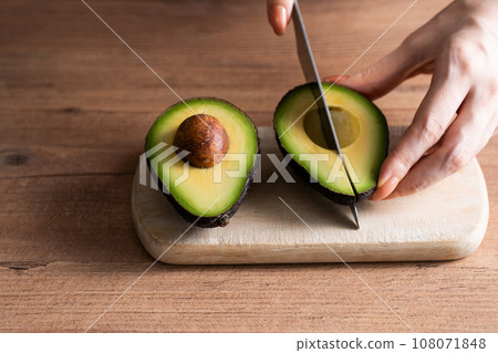 Hands cutting an avocado Hands cutting an avocado 108071848