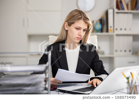 Woman bookkeeper doing paperwork in office Woman bookkeeper doing paperwork in office 108073490