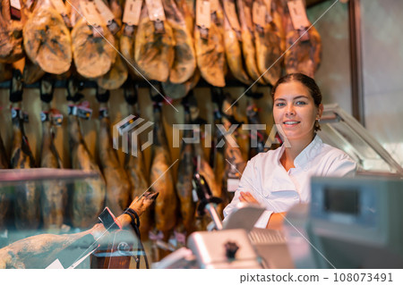 Cheerful female jamoneria worker at counter 108073491