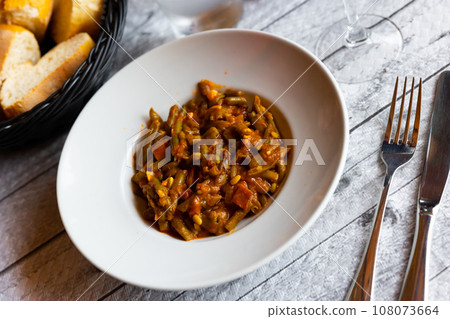 Dish of green beans with ham and tomatoes 108073664