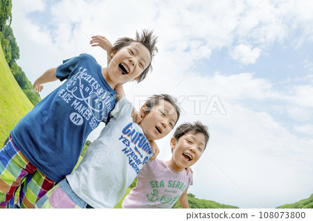 Elementary school students playing on the grass in the park 108073800