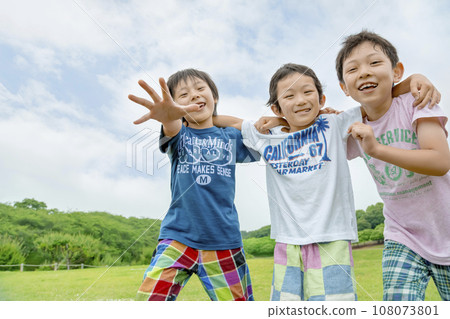 Elementary school students playing on the grass in the park Elementary school students playing on the grass in the park 108073801