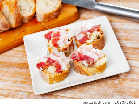 Snack for vodka, homemade salo with bread and horseradish on rustic board Snack for vodka, homemade salo with bread and horseradish on rustic board 108073861