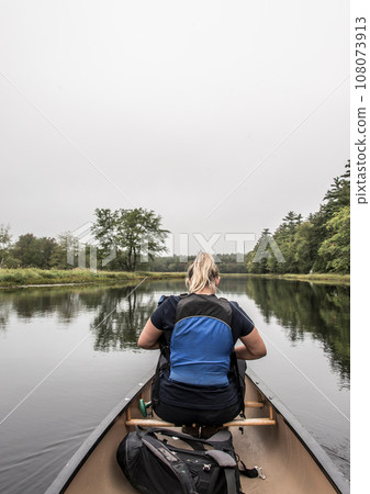 blonde Girl Canoe ride exploring nature on morning mist Kejimkujik National Park Wilderness Nova Scotia Canada 108073913