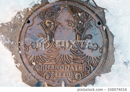 Hakodate city manhole cover with snow in winter season. Hakodate in one of landmark and popular for tourists attractions in Hokkaido, Japan. Travel and Vacation concept 108074016