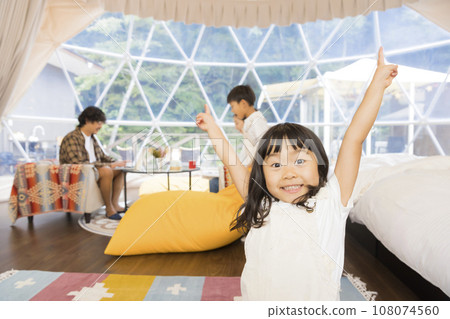 Children frolicking in a dome tent at a glamping facility 108074560