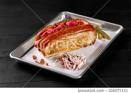 Hot dog in brioche bread with sausage, minced beef, pickled red onion 108075331
