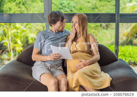 Cost of Pregnancy And Family Budgeting Concept. Young couple expecting baby, planning budget and counting spends at home 108076629